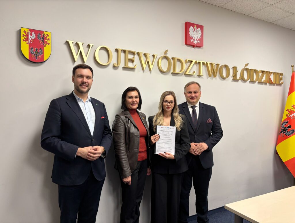 cztery osoby pozujące z dokumentem